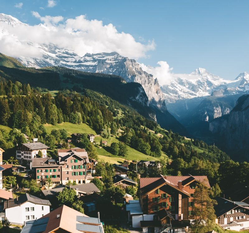 brown and white houses on green mountain under blue sky during daytime